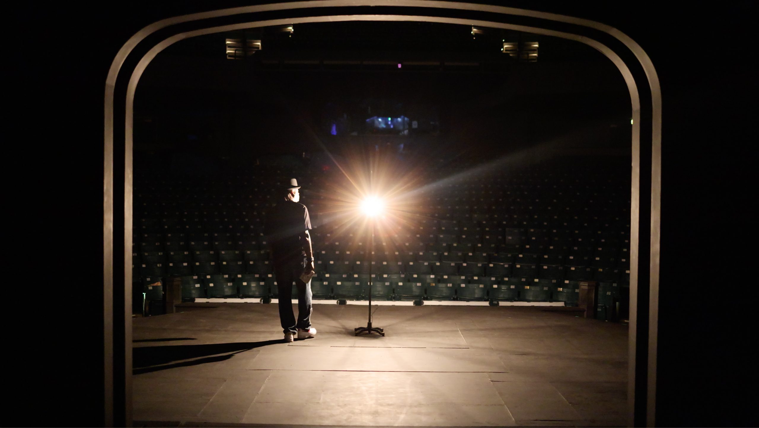 Rising Film still of man on stage